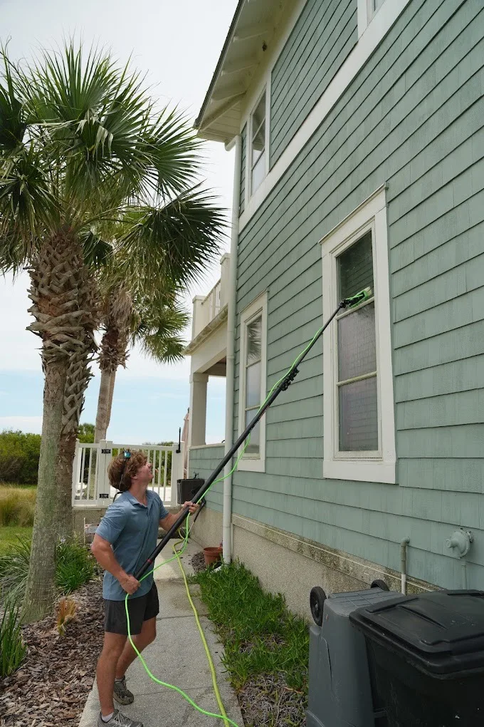 Cleaning second-story windows on a coastal St. Augustine beach house