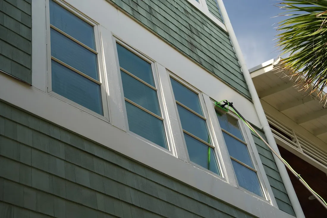 Pure water brush reaching third-story windows on a shingled coastal home